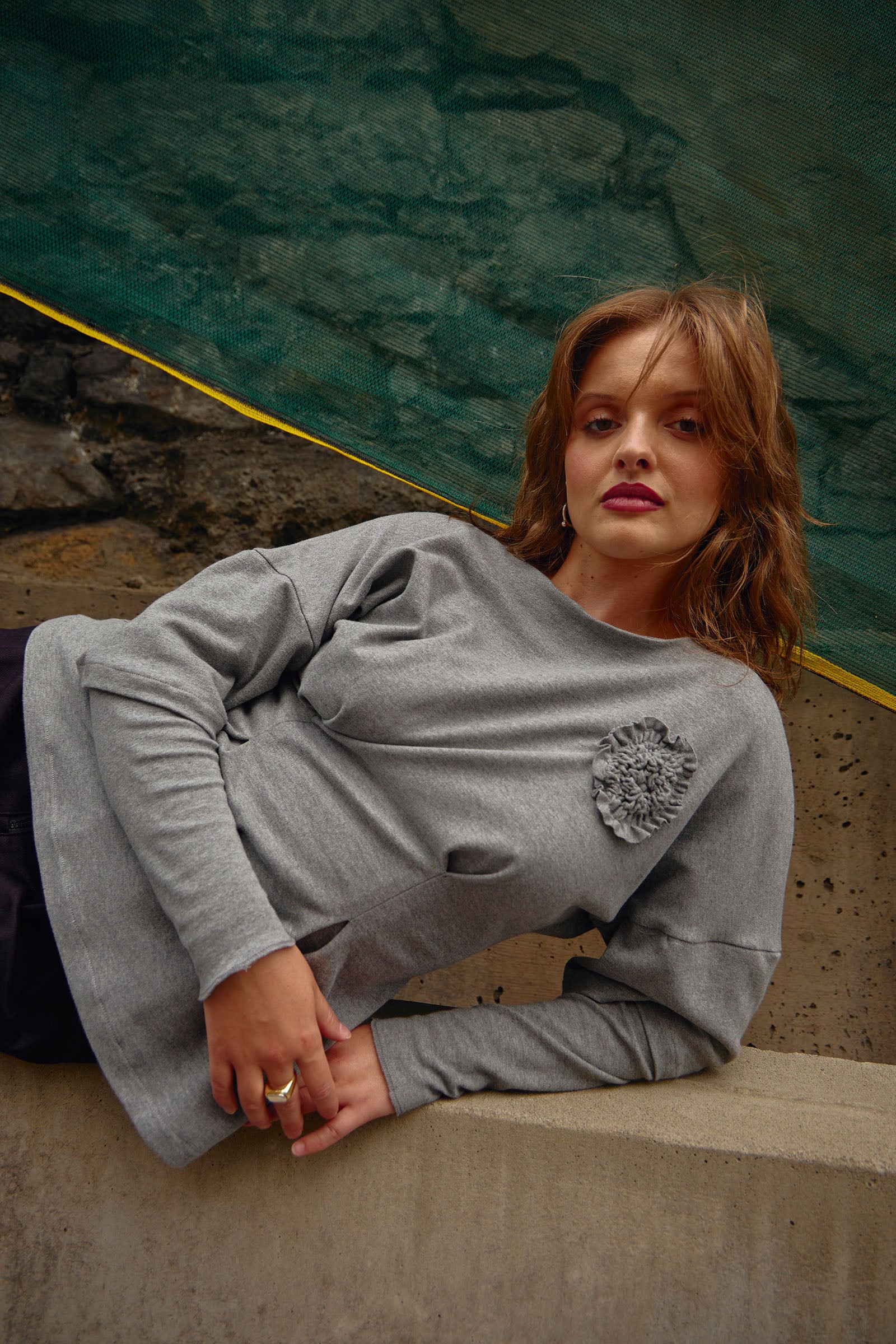 Cropped front view. Grey heather hip-length knit top with fit & flare waist, double layer sleeve appliqué flower detail at chest.
Cozy, stretchy organic cotton knit interlock fabric
