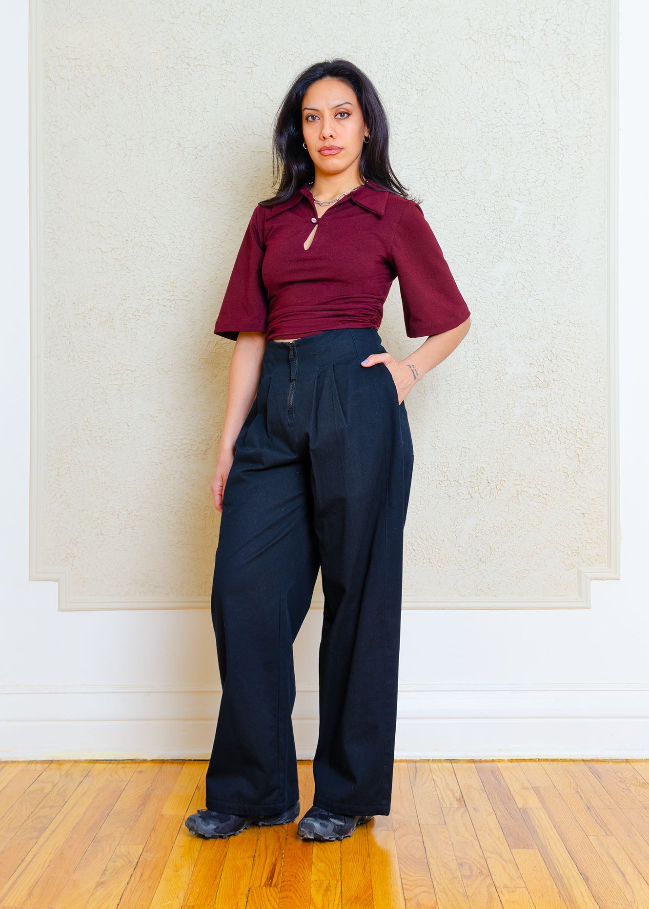 Waist length, fitted stretch knit polo top with button & loop detail, oversized collar, rouching at the side seams and flared sleeves just ending above the elbow.
This is our version of the classic polo- slightly exaggerated proportions & subtle detailing instantly updates this shirt from staple to statement.
Styled with black cotton high waisted, wide leg pleated pants with centre front zipper closure