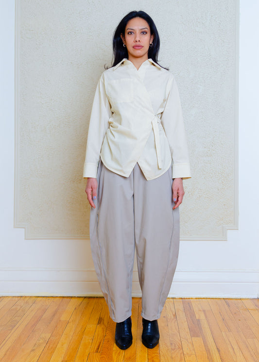 Cotton poplin shirt with asymmetrical front, adjustable waist closure with matte tortoiseshell print slider, gathering at waist side seams, shirt collar & patch pocket.Featuring an exaggerated baseball hem & back darts for a flattering, slightly fitted look.

Lightweight light yellow cotton poplin fabric features a subtle menswear-influenced stripe. 
