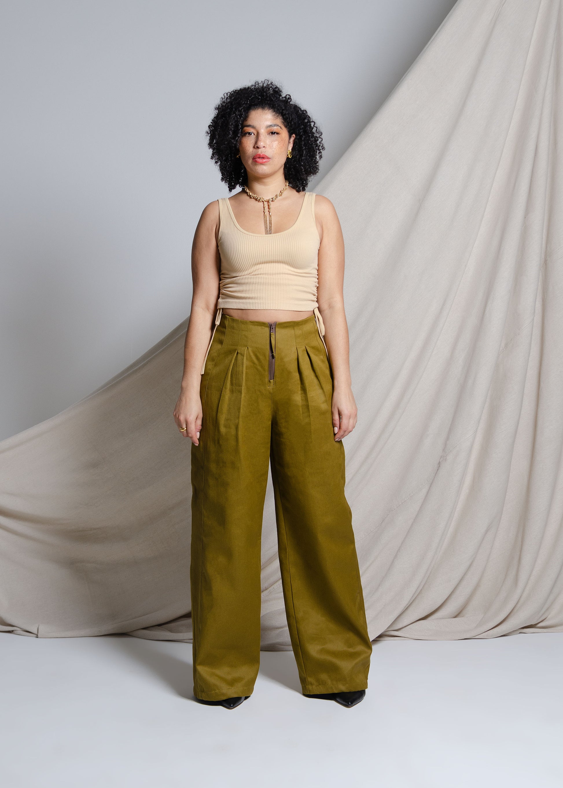 High waisted, wide leg pants with exposed zipper closure, front pleats and large back patch pockets. Invisible side pockets. Made from organic cotton / hemp blend fabric with a slight sheen.