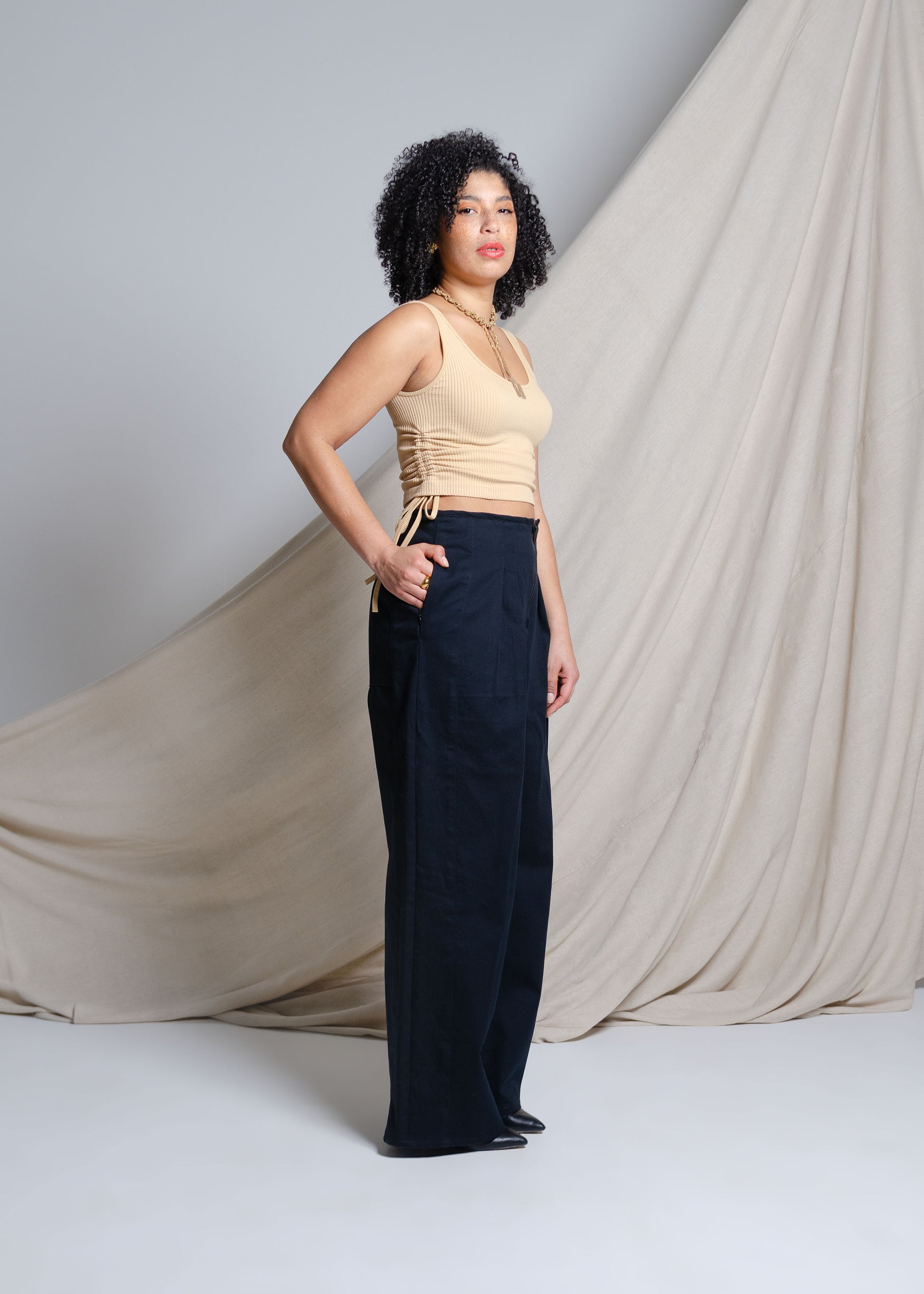 High waisted, wide leg pants with exposed zipper closure, front pleats and large back patch pockets. Invisible side pockets. Made from black 10 oz cotton twill fabric